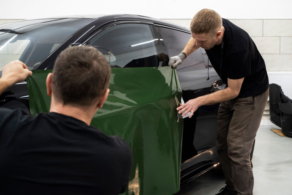 Specialist applying a sleek vinyl wrap to enhance the car’s look
