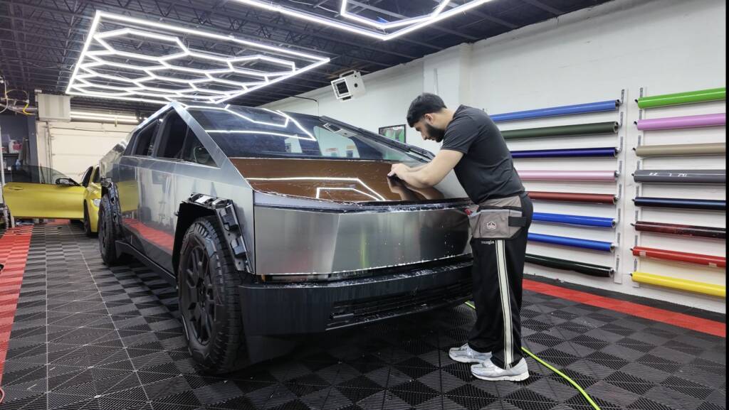 Technician carefully installing Color paint protection film on a car to prevent scratches
