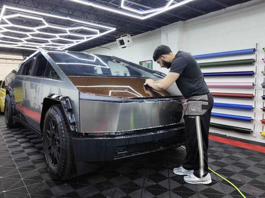 Technician carefully installing Color paint protection film on a car to prevent scratches