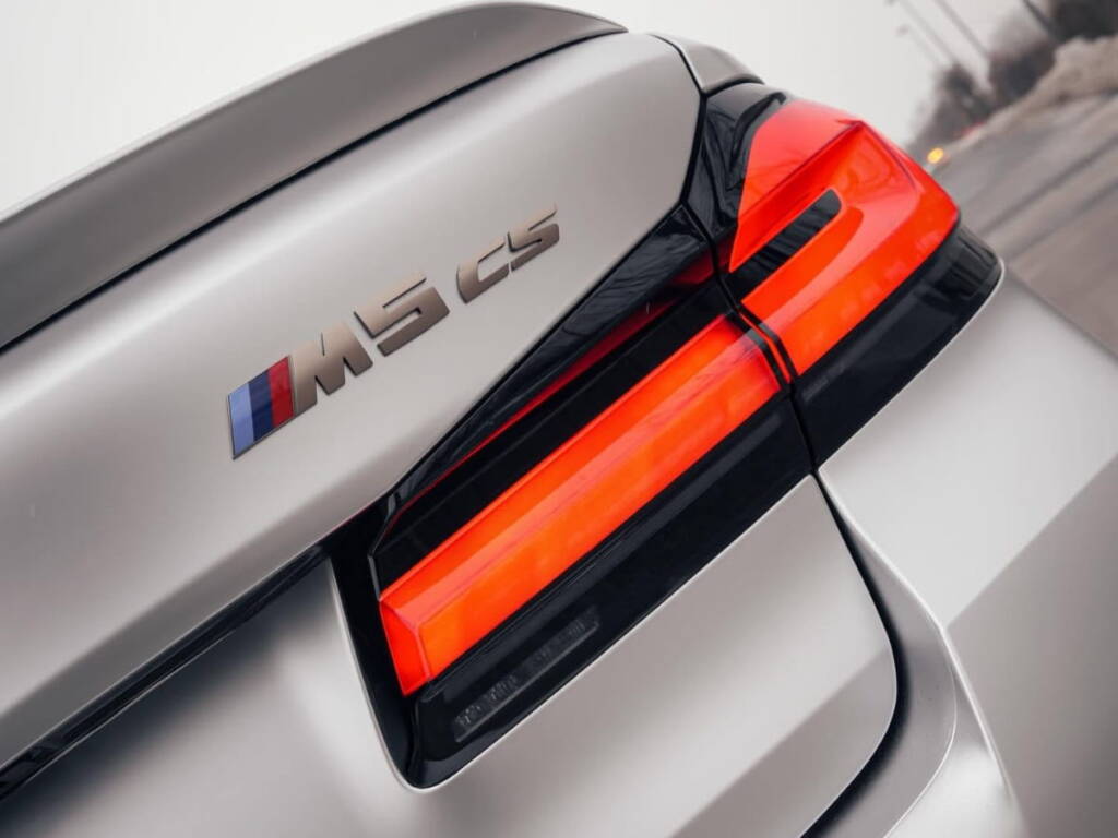 Close-up of a BMW M5 CS rear badge and taillight with a clean protected finish.