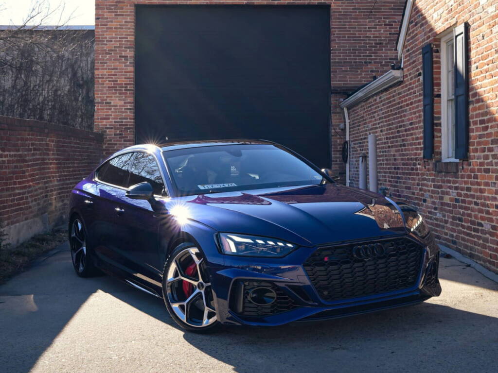 Blue Audi RS5 parked outside the Exodius Auto Protection shop.